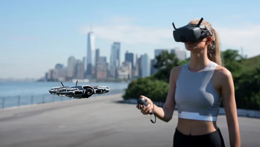 Kobieta steruje dronem DJI Neo 2  obserwując obraz na żywo z kamery za pomocą specjalnych gogli DJI Goggles N3.