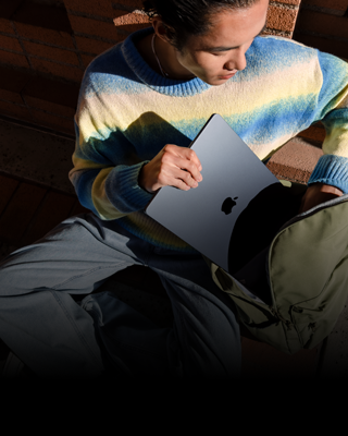 Osoba wsuwająca do plecaka 15-calowego MacBooka Air w kolorze północy