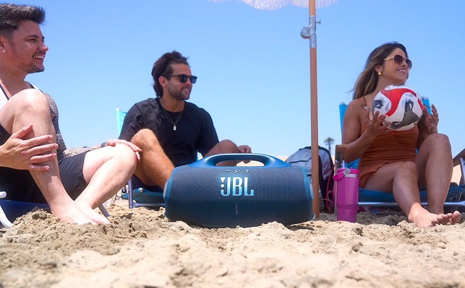 JBL Boombox 4 na piasku – ilustracja długiego czasu odtwarania muzyki przez głośnik.