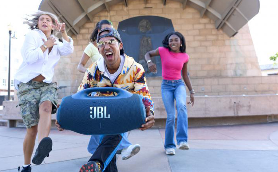 Grupa osób tańczy przy muzyce z głośnika JBL Boombox 4.