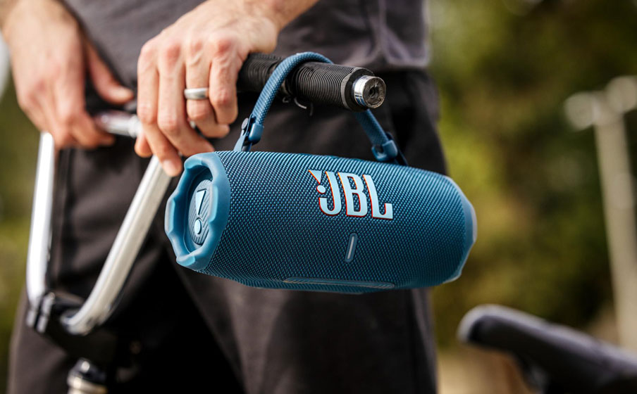 Głośnik JBL Charge 6 jest zawieszony na kierownicy roweru.