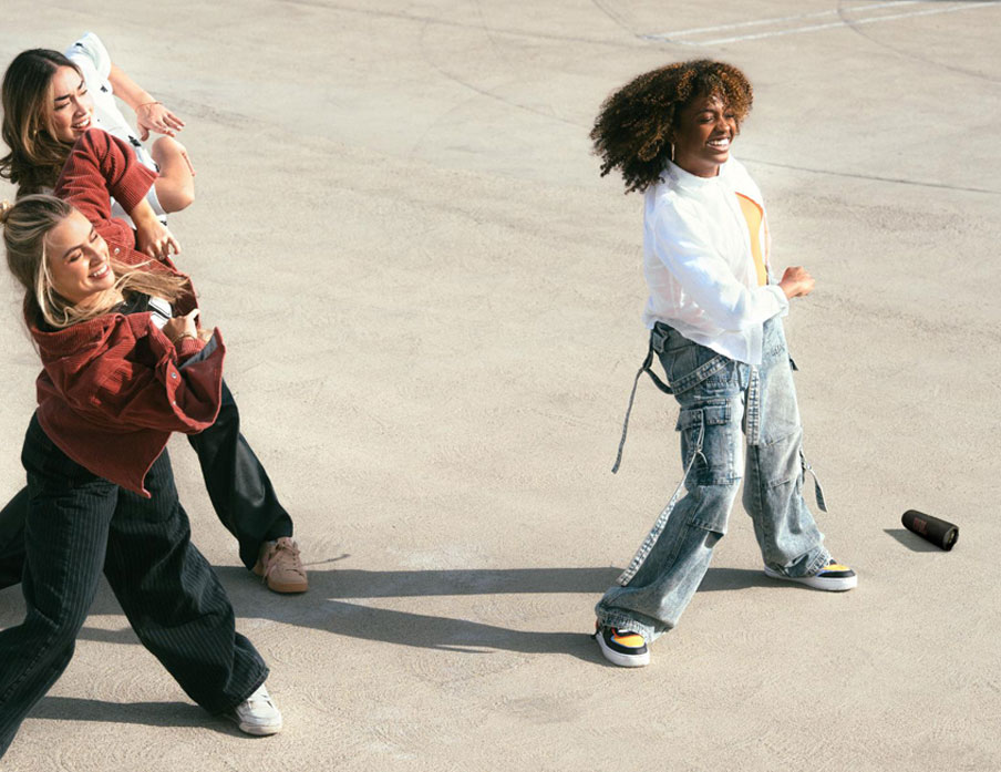 JBL Flip 7 – trzy osoby cieszą się z możliwości słuchania muzyki z funkcją dźwięku bezstratnego.