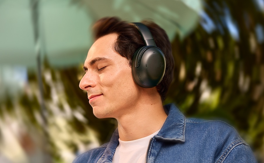 Osoba słucha muzyki wykorzystującej dźwięk przestrzenny słuchawek JBL Tour One M3