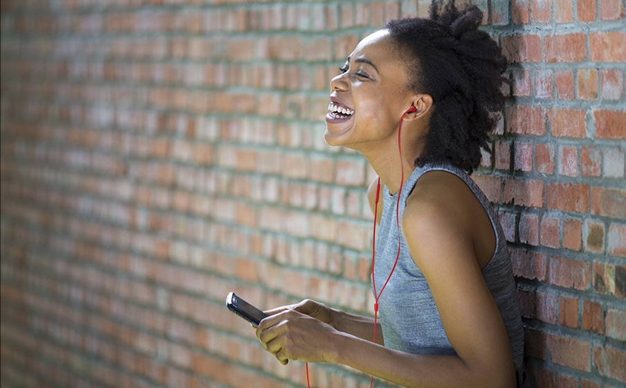 Osoba używa słuchawek JBL Tune 310C w przestrzeni publicznej.