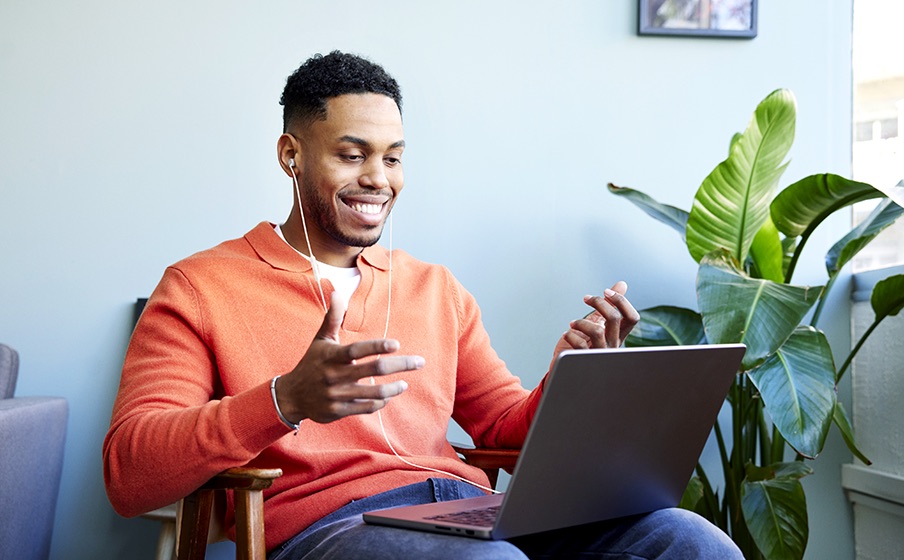 Osoba używa słuchawek JBL Tune 310C podłączonych kablem do laptopa