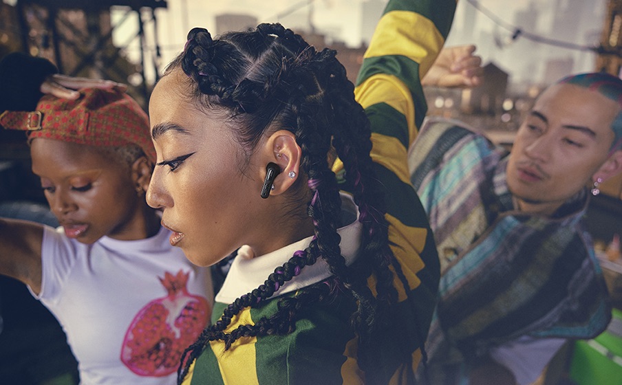 Osoba ze słuchawkami JBL Tune Flex 2 na imprezie.