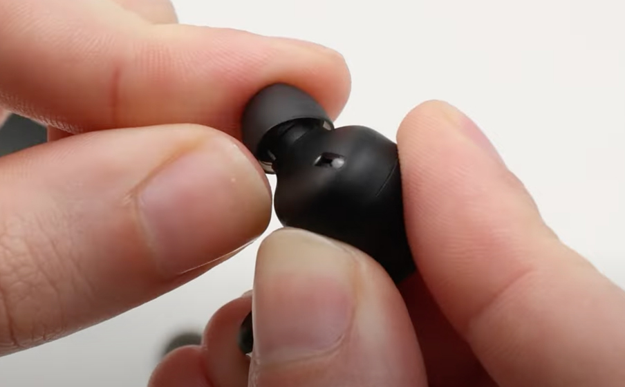 Osoba zakłada końcówkę uszczelniającą na słuchawkę JBL Tune Flex 2