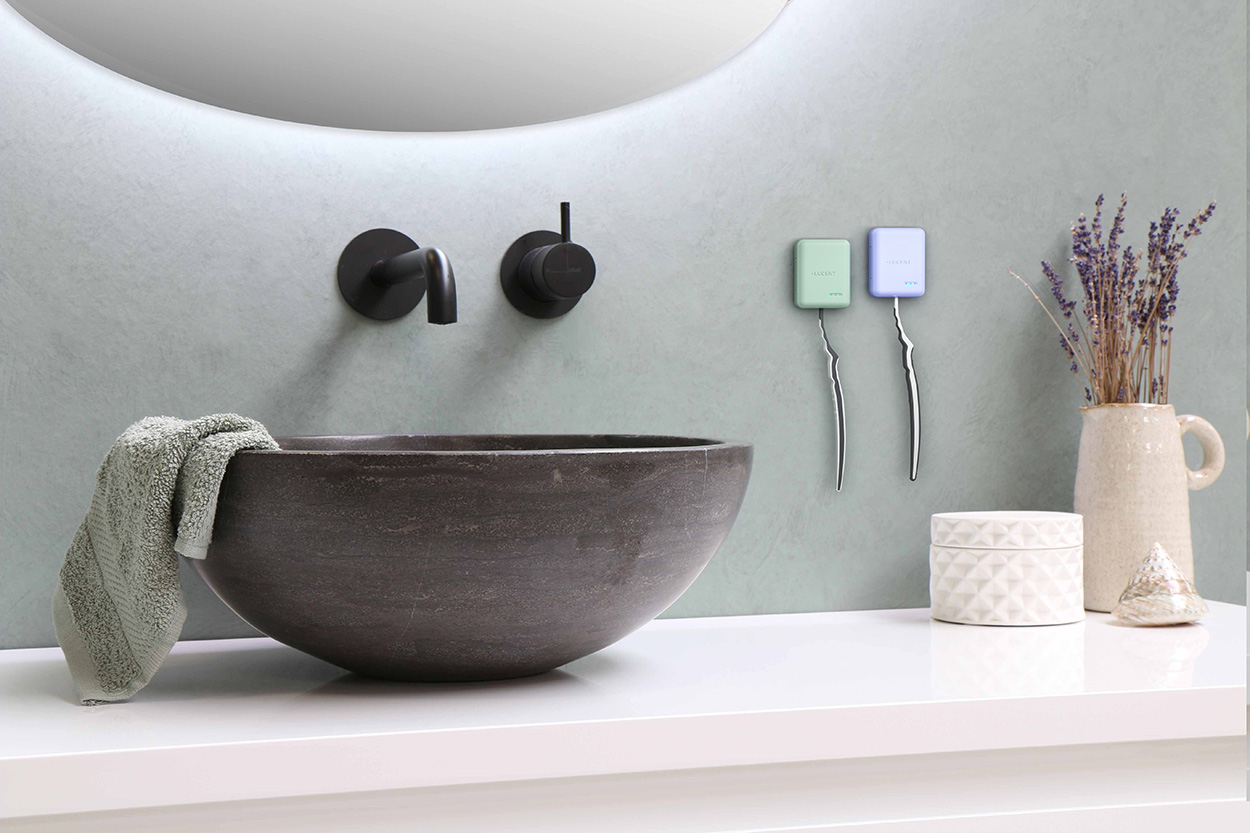 Dwa sterylizatory Lucent Aurora Toothbrush Steriliser zamontowane na ścianie obok umywalki