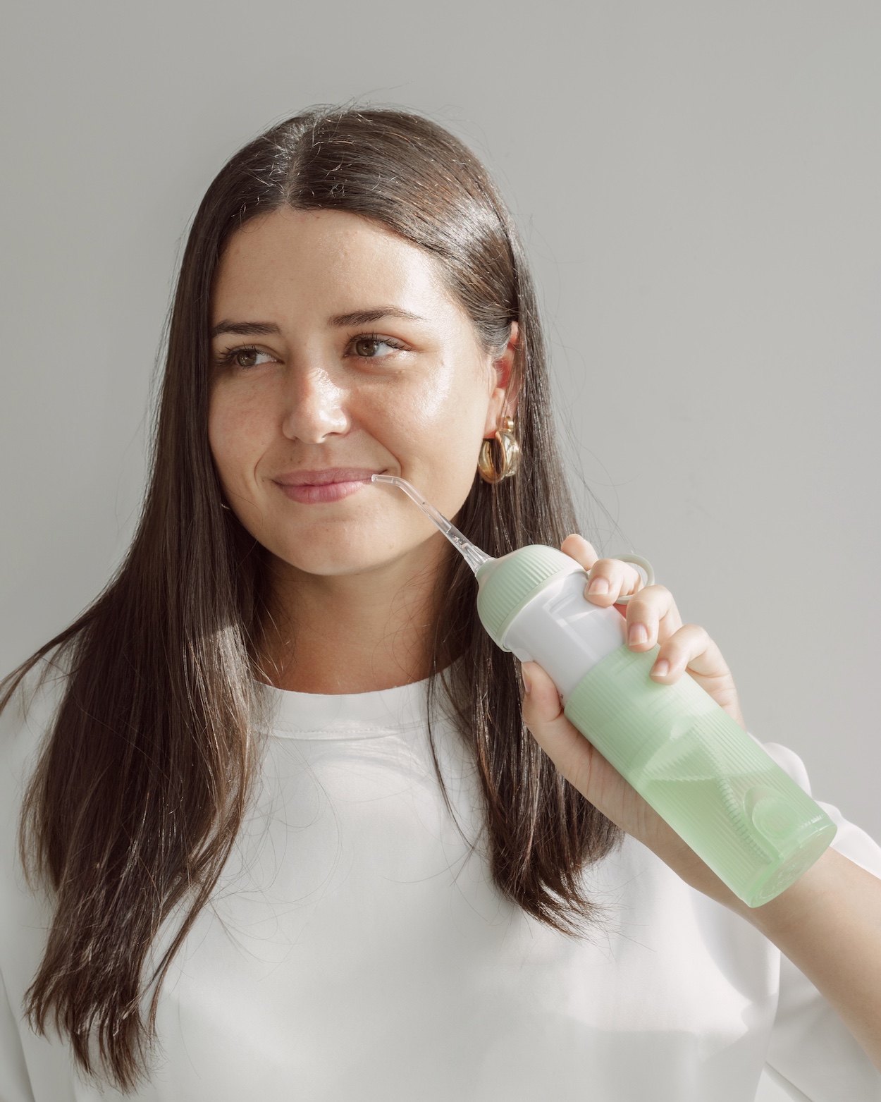 Młoda osoba używa irygatora Flare Water Flosser