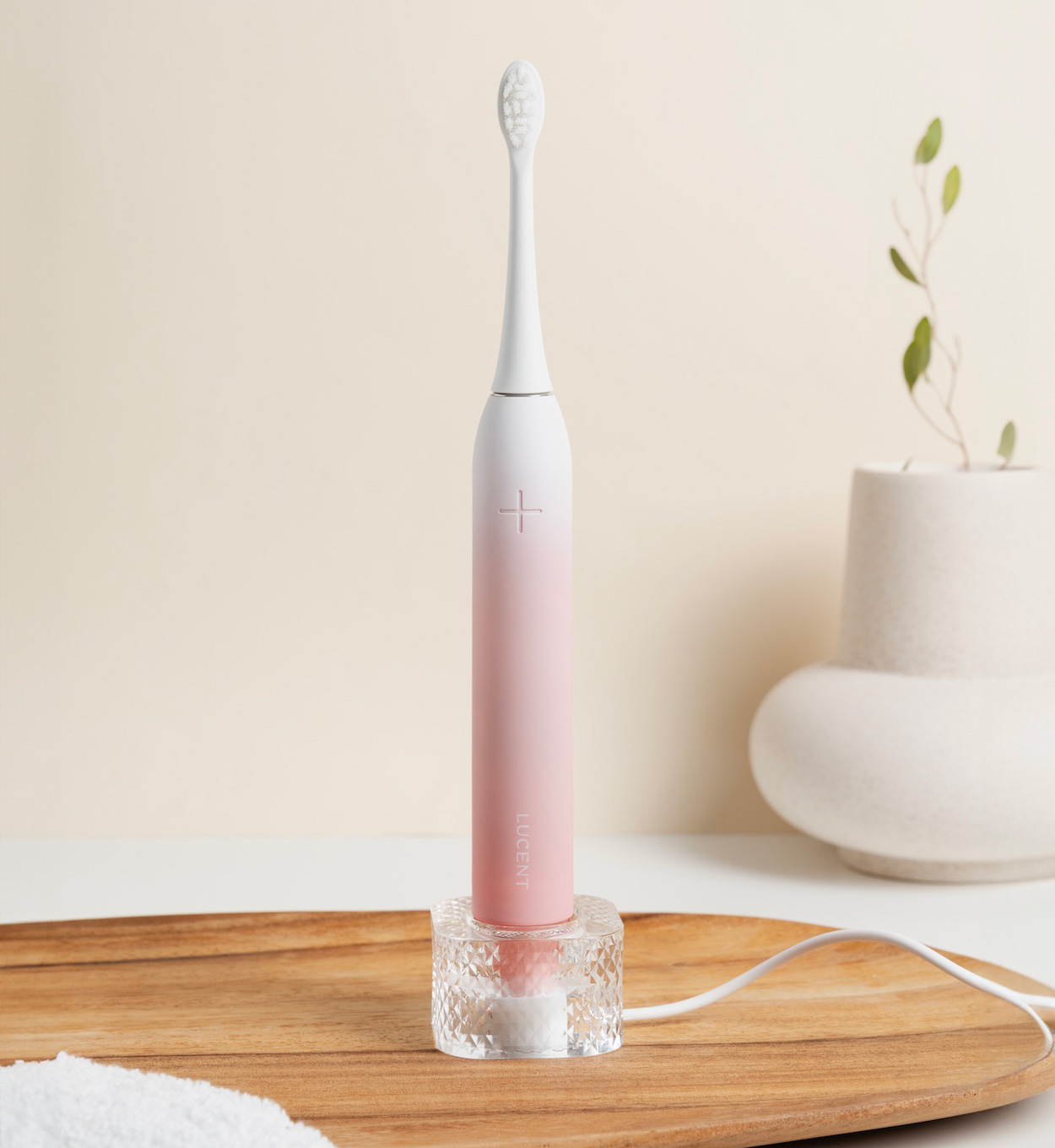 Szczoteczka Lucent Prism Sonic podczas ładowania w dołączonej ładowarce bezprzewodowej