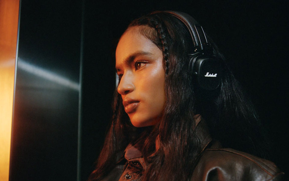 Osoba z założonymi słuchawkami Marshall Major V z widocznym logo Marshalla