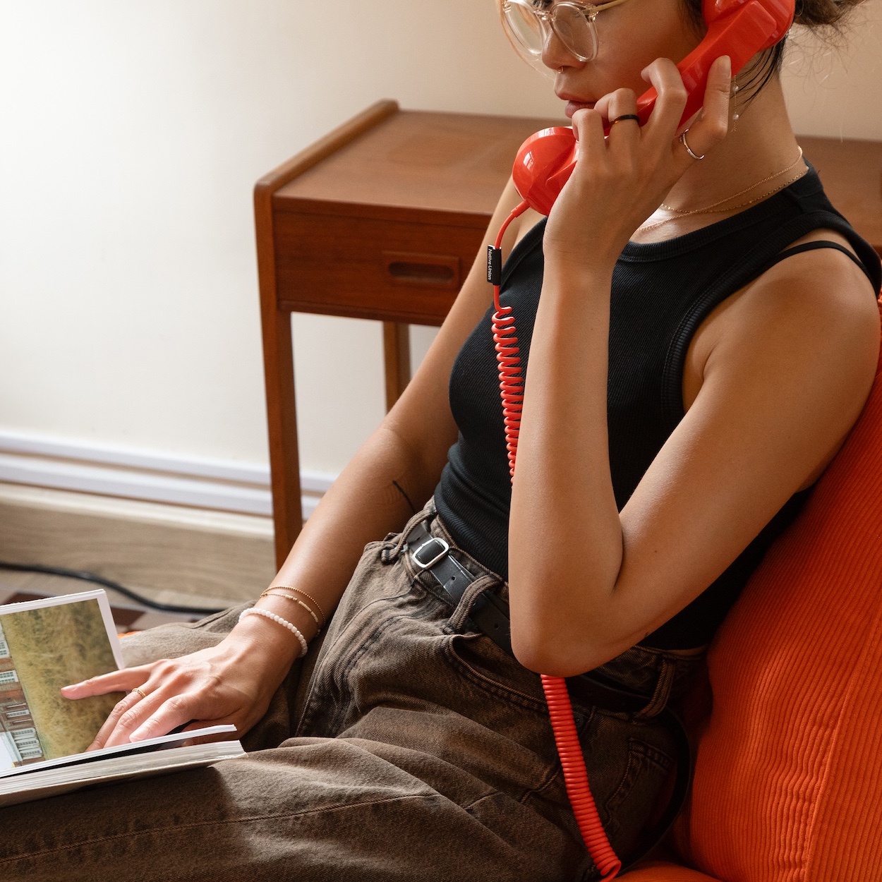 Użytkownik rozmawia przez słuchawkę Native Union POP Phone przeglądając album