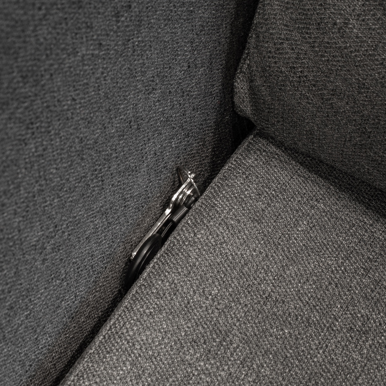 Native Union Find it Tag Pęk kluczy z lokalizatorem wsunięty między poduszkami fotela.