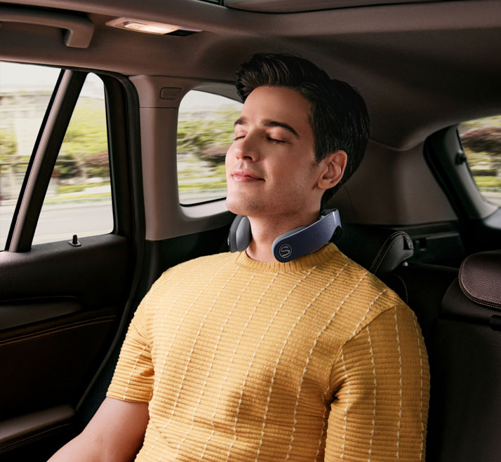 Osoba używa masażera SKG W7 Pro-Fold w samochodzie.