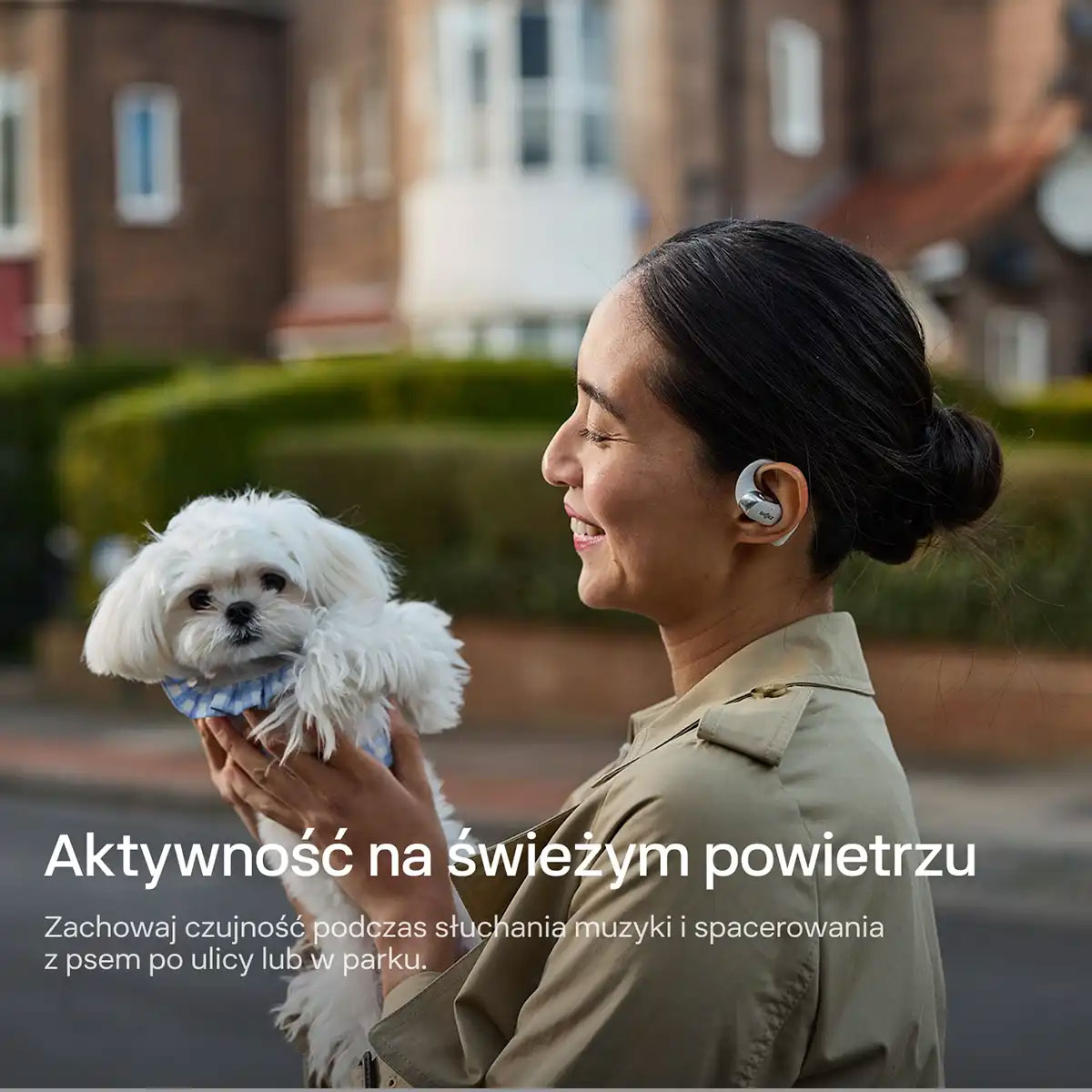 Osoba ze słuchawkami Shokz OpenFit 2+ na spacerze z psem