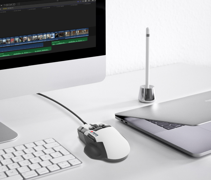 Zdjęcie myszy Swiftpoint Creator w otoczeniu laptopa, klawiatury i komputera stacjonarnego.