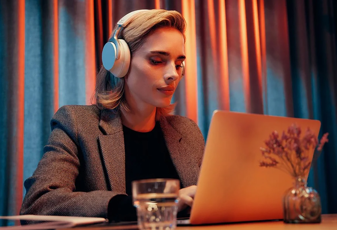 Osoba używa słuchawek beyerdynamic Aventho 200 jednocześnie z laptopem.