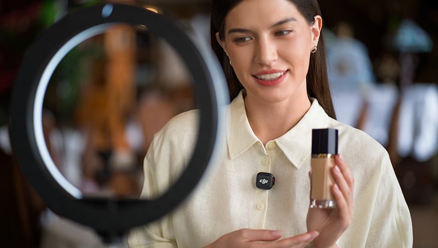 Widok mikrofonu DJI Mic 3 (2 TX+ 1 RX) przypiętego do bluzki