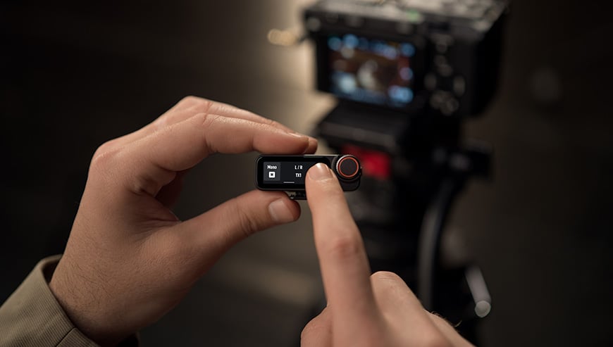 Użytkownik obsługuje DJI Mic 3 (2 TX+ 1 RX) korzystając z jego ekranu dotykowego