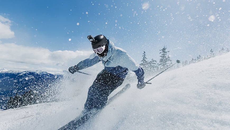 Narciarz zjeżdża ze stoku z kamerą na kasku
