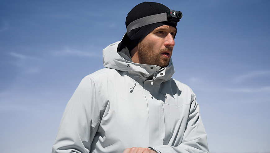 Podróżnik z kamerą DJI Osmo Nano umieszczoną na czapce za pomocą opaski.