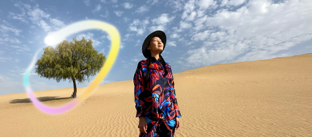 Widoczny od przodu iPad Pro, na ekranie wiele otwartych aplikacji na tle o gradiencie od ciemnoniebieskiego do zielonego. Dłoń trzyma rysik Apple Pencil Pro i zakreśla szkic, używając funkcji różdżki graficznej Apple Intelligence