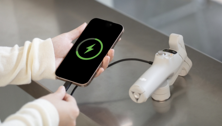 Zdjęcie przedstawia ładowanie smartfona z akumulatora gimbala DJI Osmo Mobile 7.