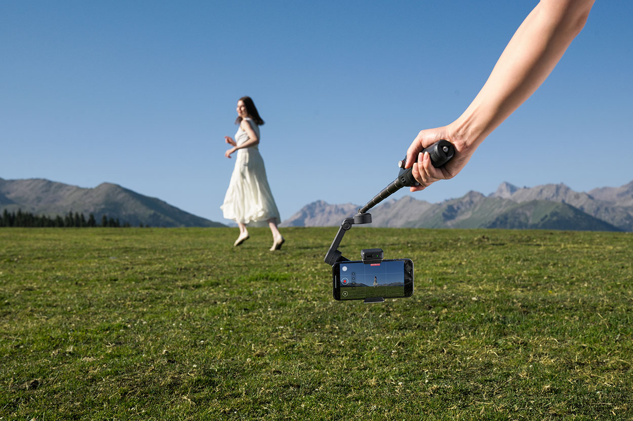 Użytkownik nagrywa osobę, która biegnie przez łąkę.