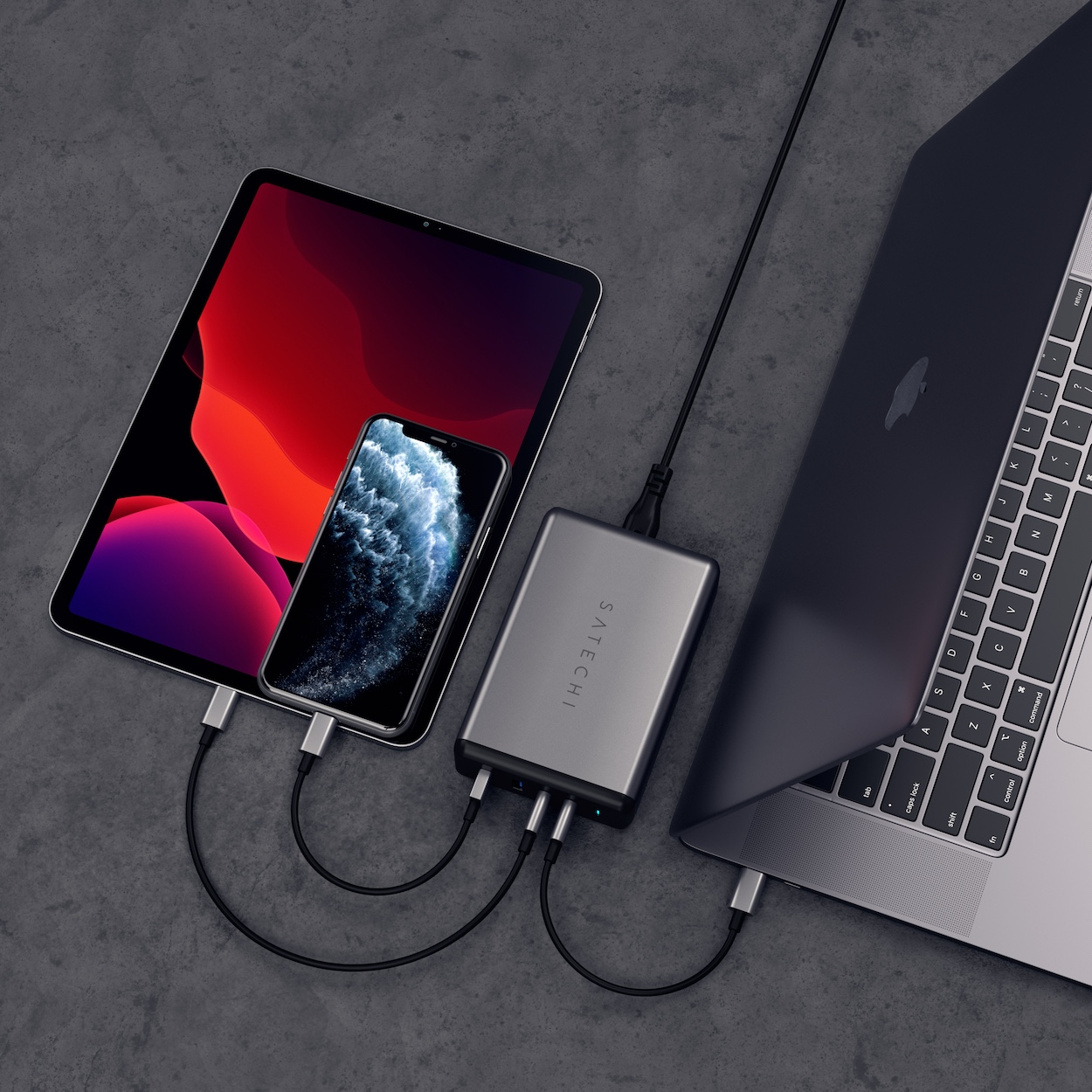 Zdjęcie pokazuje jednoczesne ładowanie trzech urządzeń z wykorzystaniem dwóch portów USB-C i jednego portu USB-A ładowarki Satechi Desktop 108W Pro 108W 2x USB-C PD 2x USB-A.
