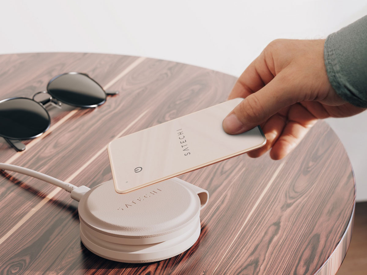 Użytkownik umieszcza lokalizator Satechi FindAll Wallet Card na ładowarce bezprzewodowej