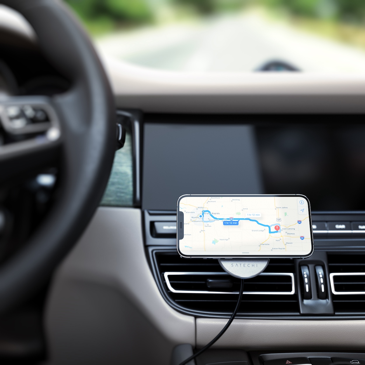 Smartfon na ładowarce Satechi Magnetic Wireless Car Charger wyświetla mapę z nawigacją.