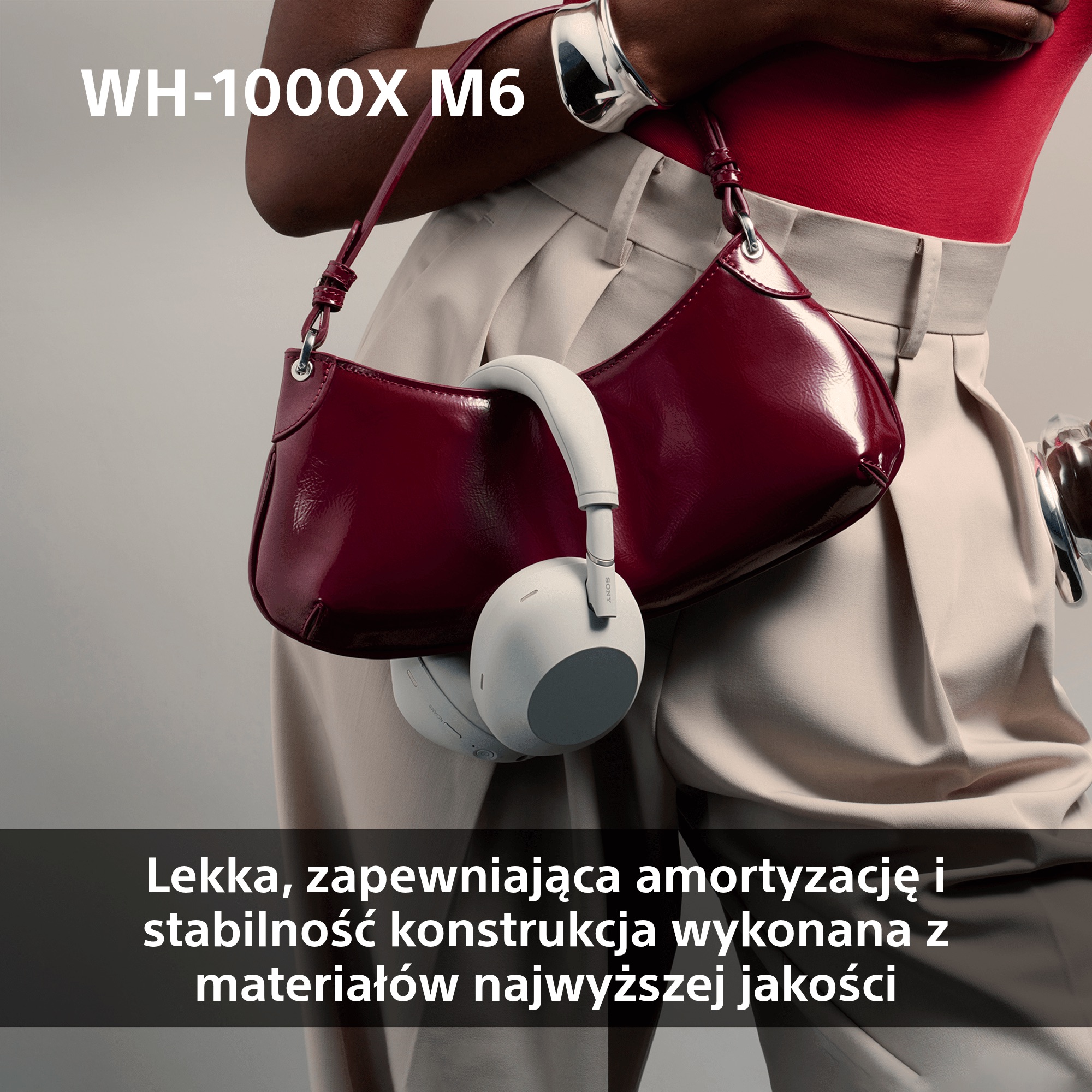 Sony WH-1000XM6 Białe słuchawki Sony WH-1000XM6 zawieszone na eleganckiej damskiej torebce
