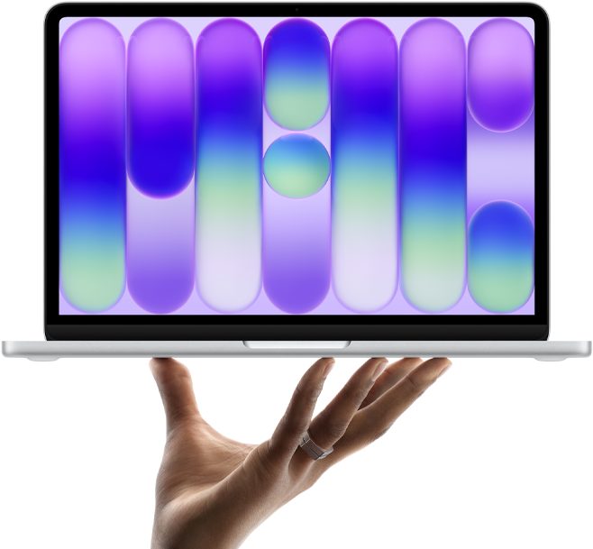 MacBook Neo w kolorze cytrusowożółtym, leżący na palcach otwartej dłoni, na ekranie widać kolorowy abstrakcyjny wzór