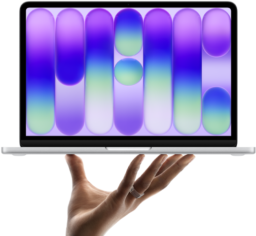 MacBook Neo w kolorze cytrusowożółtym, leżący na palcach otwartej dłoni, na ekranie widać kolorowy abstrakcyjny wzór